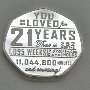 May include: A silver coin with the inscription "You Loved for 21 Years" and a breakdown of the time in weeks, days, hours, and minutes. The coin also says "That is 252 Months" and "and counting!"