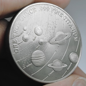 Moneda, lingote o ronda de TITANIO puro y fino de 0,999. Nuestro sistema solar. Una onza troy de 31,1 g. Inversión/lingote