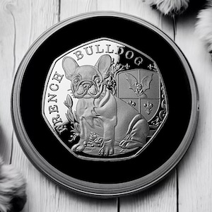 Może przedstawiać: Srebrna moneta z wizerunkiem buldoga francuskiego. Na monecie widnieje napis "French Bulldog" oraz herb z nietoperzem.