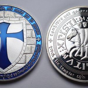 K&ouml;nnte beinhalten: Silberm&uuml;nze mit einem blauen Kreuz auf einem Schild auf der einen Seite und einem Ritter zu Pferd auf der anderen Seite. Die M&uuml;nze tr&auml;gt die Inschrift "Douperos commiiiformes cruist templique + non adfile ruumine fumulx, xed nomini tuo an mplique salomunici nicrusslemitomis trech gloriam +" auf der einen Seite und "LVMSTUILIT echtiin temples com uthtxin cambiare wedgwTLTL PISTI:HSTO A POXXXX +" auf der anderen Seite.