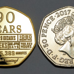 May include: A 50 pence coin commemorating Queen Elizabeth II's 90th birthday. The coin features a portrait of the Queen on one side and a design with the text "90 YEARS" and a breakdown of her reign in decades, months, weeks, days, hours, and minutes on the other side.