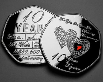 Puede incluir: Dos monedas conmemorativas de plata con un diseño de corazón rojo. La primera moneda dice "10 YEAR That is... Decade 524 Weeks 5,859,600 and still counting..." La segunda moneda dice "For You On Your 10th Wedding Anniversary 10 Years Together".