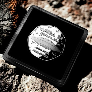 May include: A silver coin with a UFO and the text "AREA 51 NEVADA, USA" on it. The coin is in a black velvet box.