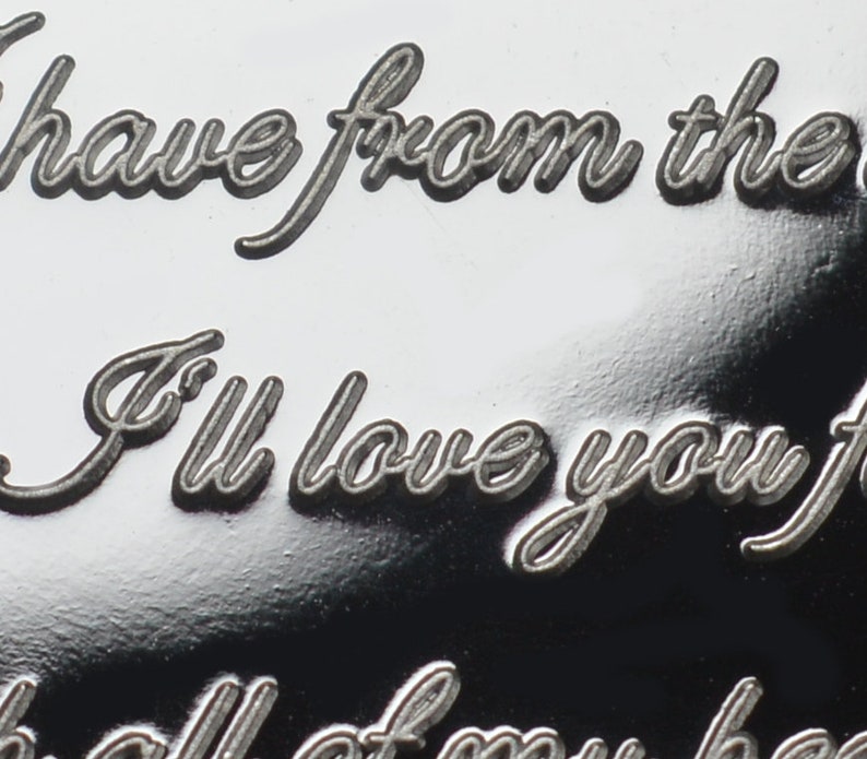 May include: Close-up of a silver engraved heart pendant with the inscription "I have from the I'll love you f all of my he"