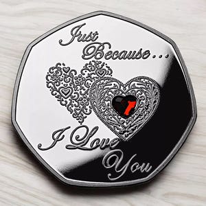 Puede incluir: Una moneda de plata con un corazón rojo y las palabras "Just Because... I Love You" en ella.