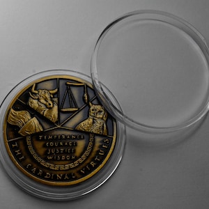 May include: A gold-toned coin with a design featuring a bull, scales, an owl, and the words "The Cardinal Virtues" and "Temperance, Courage, Justice, Wisdom". The coin is in a clear plastic case.