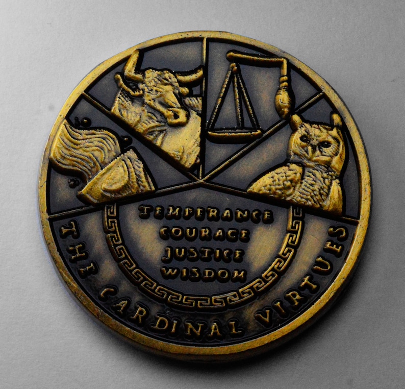 May include: A gold-toned metal coin with a black background. The coin features a bull, a scale, an owl, and a torch. The words "The Cardinal Virtues" are inscribed around the edge of the coin. The words "Temperance, Courage, Justice, Wisdom" are inscribed in the center of the coin.