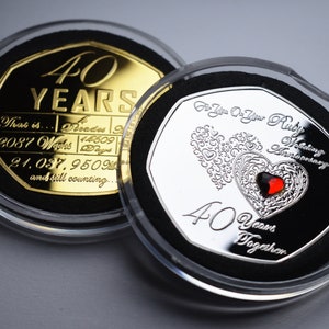 May include: Two silver and gold coins in display cases. The silver coin has a ruby heart and the text "For You On Your Ruby Wedding Anniversary 40 Years Together". The gold coin has the text "40 YEARS That is... 2087 Weeks 44609 Days 21.037.9509 and still counting..."