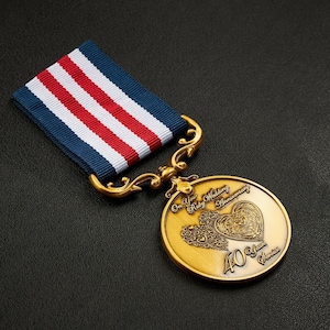 May include: A gold-coloured medal with a red and white heart design and the text "On Your Ruby Wedding Anniversary 40 Years Service". The medal is attached to a blue and red ribbon.