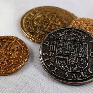 以下が含まれることがあります： 複雑なデザインが施された、アンティークの金貨と銀貨4枚。コインには十字架と紋章が描かれています。