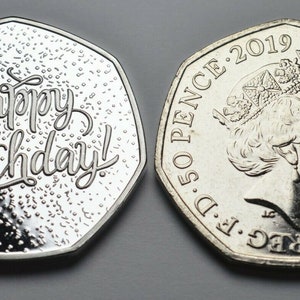 May include: A silver 50 pence coin with a design of Queen Elizabeth II on one side and the words "Happy Birthday!" on the other side. The coin is dated 2019.