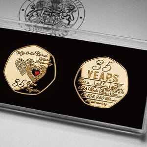 May include: A gold-colored commemorative coin set celebrating a 35th wedding anniversary. The coin on the left features a heart design with a red center, and the text "35 Years Together". The coin on the right has the text "35 YEARS". The coins are displayed in a clear plastic case.