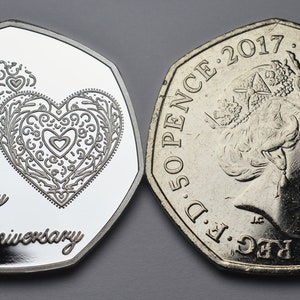 May include: A silver 50 pence coin with a design of two intertwined hearts and the text "Happy Anniversary" on one side. The other side features a profile of Queen Elizabeth II and the year 2017.