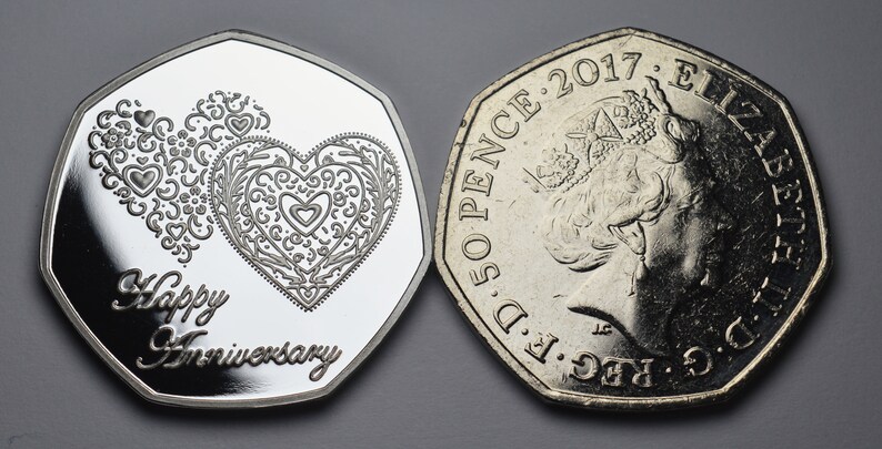May include: A silver 50 pence coin with a design of two intertwined hearts and the text "Happy Anniversary" on one side. The other side features a profile of Queen Elizabeth II and the year 2017.