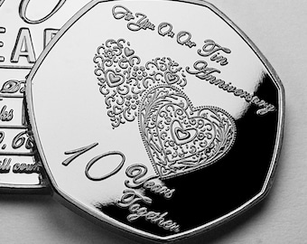 Puede incluir: Una moneda de plata con el texto "For You On Our 10th Anniversary" y "10 Years Together". La moneda presenta dos corazones ornamentados con detalles florales y en forma de corazón. Es un artículo conmemorativo.
