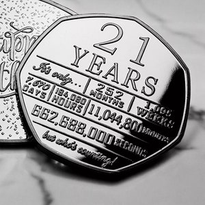 May include: A silver coin with the number 21 and the words "YEARS" printed on it. The coin also has the text "It's only... 252 MONTHS | 1,095 WEEKS | 7,670 DAYS | 184,080 HOURS | 11,044,800 MINUTES | 662,688,000 SECONDS but who's counting!" printed on it.