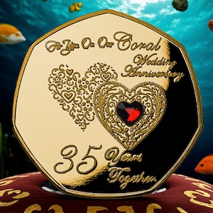 May include: A gold-colored coin with a black and gold heart design, featuring a red gem. The coin is inscribed with "For You On Our Coral Wedding Anniversary" and "35 Years Together."
