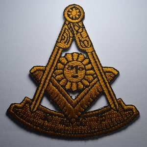 May include: Gold embroidered patch with a Masonic symbol, featuring a compass and square, a sun with a face, and the text "Freemasonry".