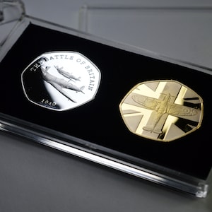 Par de monedas conmemorativas de la Batalla de Inglaterra y el Supermarine Spitfire en plata y oro de 24 quilates en una vitrina de 50 peniques. Segunda Guerra Mundial 1940 Segunda Guerra Mundial