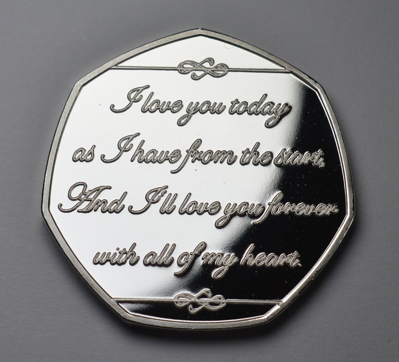 May include: Silver coin with a romantic message engraved on it. The message reads: "I love you today as I have from the start, And I'll love you forever with all of my heart."