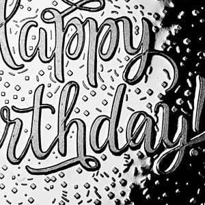 May include: Black and white image of the words "Happy Birthday" written in a cursive script. The background is a white surface with a black and white pattern.