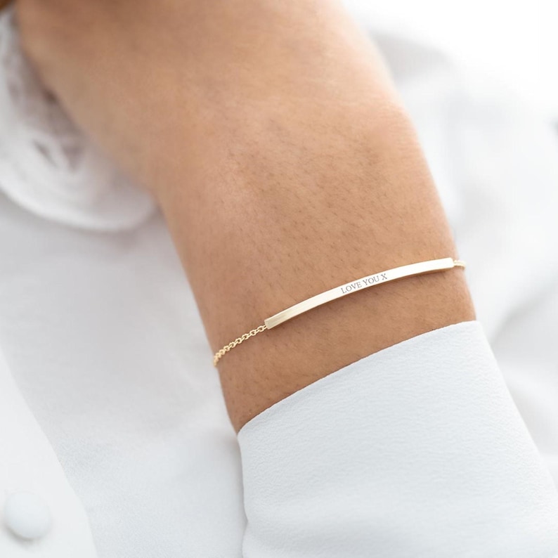 Female hand with a skinny slider bracelet with the name Isla Grace engraved on it
