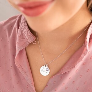 Model wearing silver Birthday Disc Name Necklace, large disk with name engraved, small disk with age engraved and birthstone.