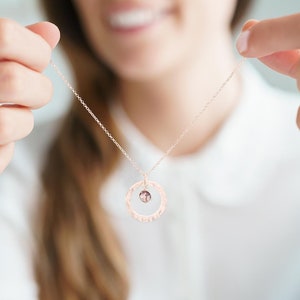 Model holding a Hammered Halo Birthstone Personalised Necklace in Rose Gold