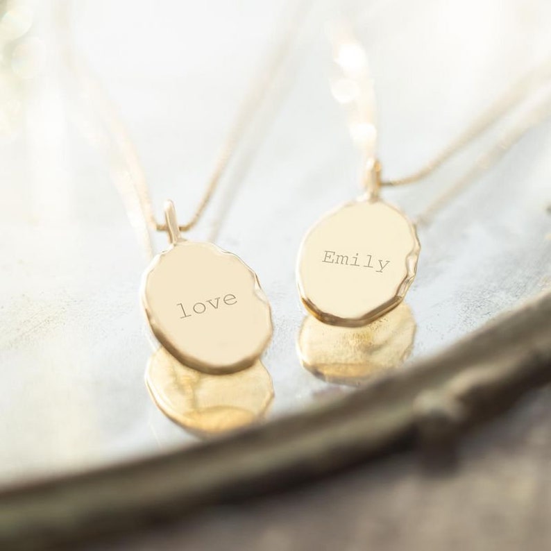Gold Oval Pendant Necklace Showcasing Personalisation on Back of Charm With Typewriter Message or Name