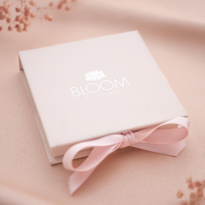 Closed gift box packaging with embossed Bloom Boutique logo and tied with a ribbon
