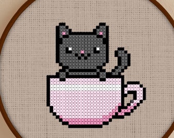 May include: A cross-stitch embroidery hoop with a gray cat sitting in a pink teacup. The hoop is on a light beige surface. The text "Snailfishes Stitches" is at the bottom of the image.
