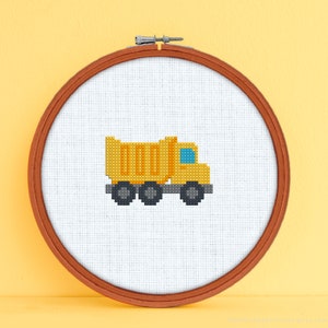 May include: A yellow dump truck cross-stitch pattern in a wooden embroidery hoop.