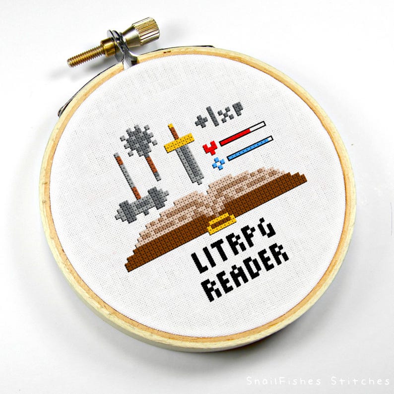May include: A white embroidery hoop with a brown book, swords, and other weapons. The text "LITRPG READER" is below the book.