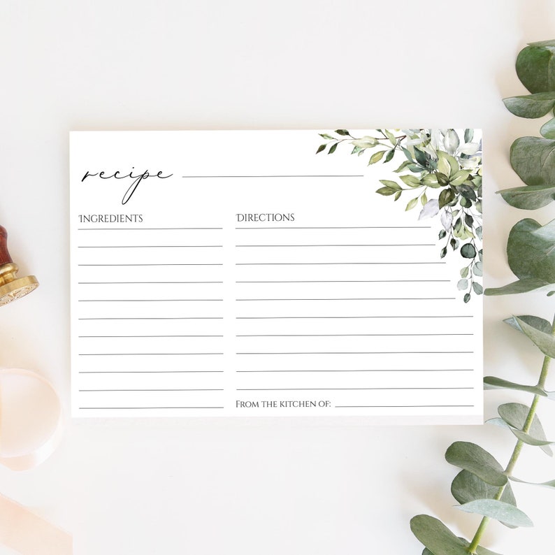 May include: A blank recipe card with a green watercolor floral design in the top right corner. The card is divided into two sections, one for ingredients and one for directions. The bottom of the card says "From the kitchen of:"