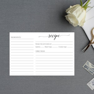 May include: A blank white recipe card with the word "recipe" written in cursive at the top. The card has sections for ingredients, directions, from the kitchen of, serves, prep time, and cook time.