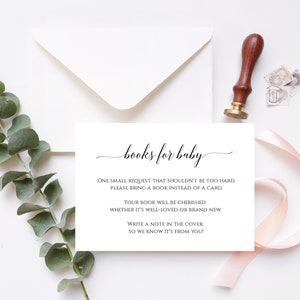 Pu&ograve; includere: Un biglietto bianco con testo nero che dice "books for baby". Il testo continua con "One small request that shouldn't be too hard. Please bring a book instead of a card. Your book will be cherished whether it's well-loved or brand new. Write a note in the cover, so we know it's from you!"