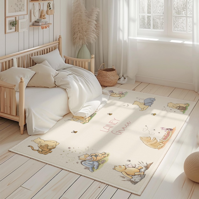 May include: An off-white rectangular rug with illustrations of Winnie the Pooh characters. The rug has the name "Lainey Grace" in cursive. The rug is in a child's bedroom with a wooden bed and white bedding.