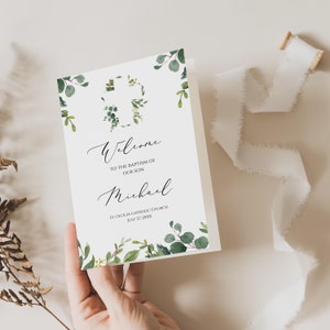 May include: A white card with green watercolour leaves and a cross design. The text reads "Welcome to the baptism of our son Michael St. Cecilia Catholic Church July 27, 20XX".