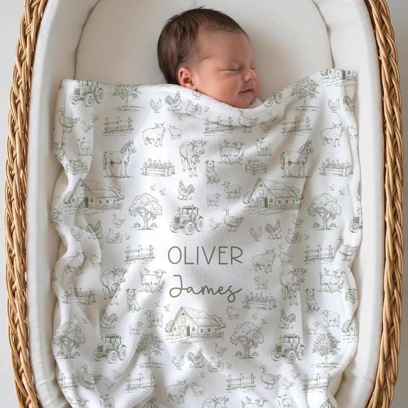 May include: A white baby blanket featuring a repeating olive green farm-themed pattern of tractors, barns, trees, and various animals. The center of the blanket is personalized with the name Oliver James in a mix of block and script fonts.
