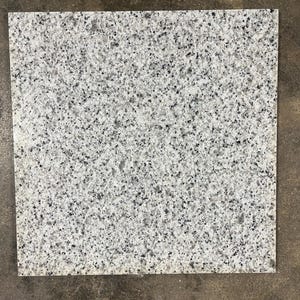 May include: A white square tile with a speckled gray pattern.