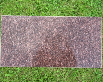 May include: A rectangular slab of brown granite with a speckled pattern. The granite is smooth and polished.