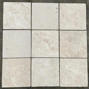 May include: Nine beige square tiles with a natural stone appearance. The tiles have a slightly textured surface with variations in color, ranging from light cream to tan. The arrangement is a 3x3 grid, suitable for flooring or wall applications.