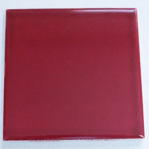 May include: A solid red ceramic tile with a glossy finish.