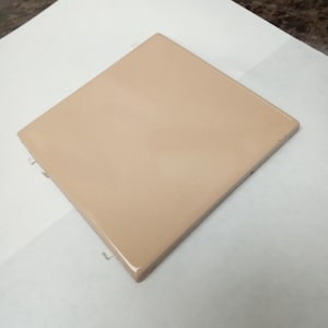 May include: A square, solid light beige ceramic tile with a smooth, glossy finish. The tile features clean, straight edges and a uniform, flat surface color throughout, presenting a simple, geometric shape with a reflective, polished appearance.