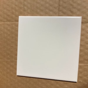 May include: A plain white ceramic tile.
