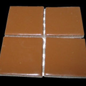 May include: Four brown ceramic tiles, each measuring approximately 1 inch by 1 inch.