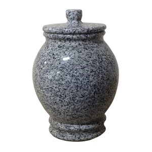 May include: A gray granite urn with a lid. The urn has a rounded body and a flared base.