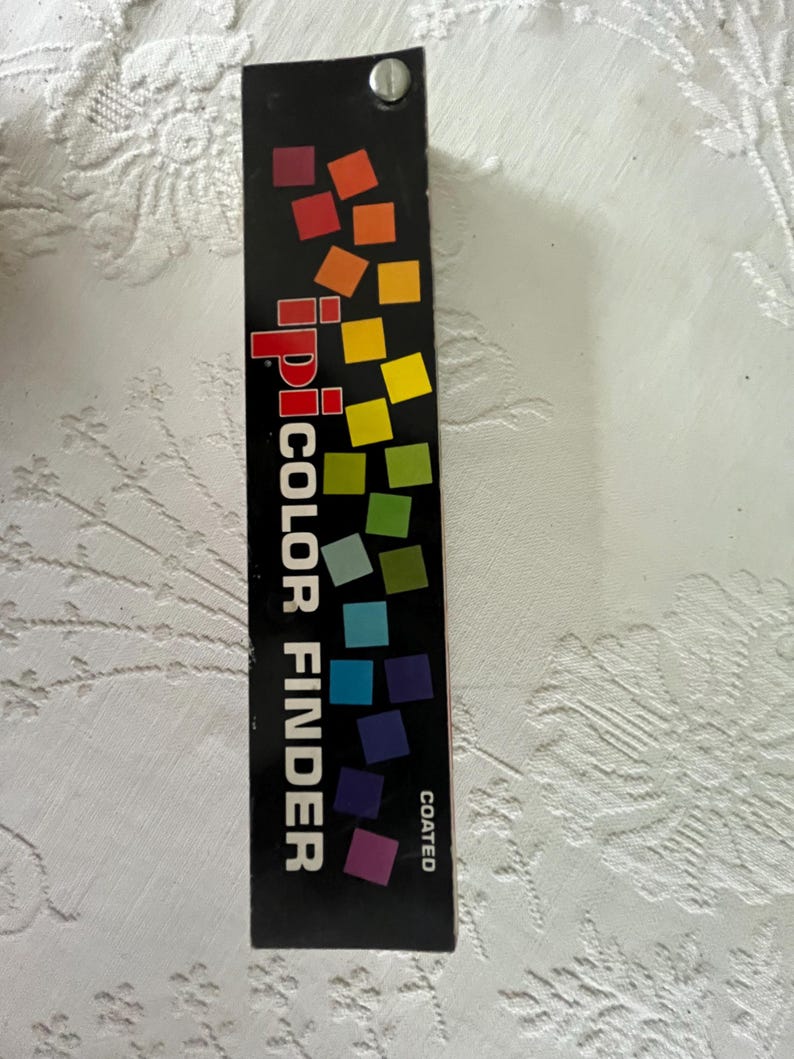 Peut inclure: Une carte de recherche de couleur noire et blanche avec un arc-en-ciel d'&eacute;chantillons de couleur. La carte est &eacute;tiquet&eacute;e "ipi COLOR FINDER" et "COATED".