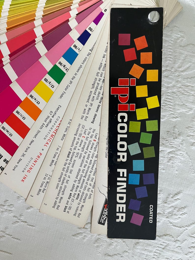 Peut inclure: Un guide de couleurs vintage IPI Color Finder avec un nuancier noir et blanc. Le guide pr&eacute;sente un nuancier en &eacute;ventail avec une vari&eacute;t&eacute; de nuances de rouge, &eacute;tiquet&eacute;es avec des codes de couleurs et des descriptions. Le guide est intitul&eacute; "IPI Color Finder" et "Coated".