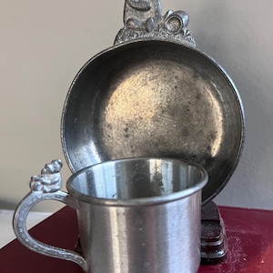 May include: A set of three ceramic mugs with a speckled, matte finish. The mugs are in shades of cream, light gray, and dark gray. Each mug has a simple, minimalist design and a rounded handle.